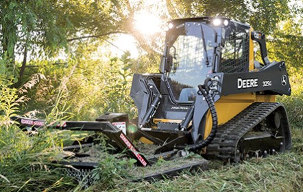 John Deere 325G skid steer running a rotary cutter to clear brush on a North Texas property